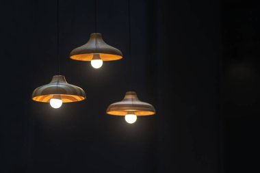 Modern grup tavan lambalarından oluşan ahşap set ofis inşaatı ya da ev ve canlı akitecture dekorasyon modern konsept için arka planda koyu renk ampuller içerir.