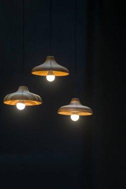 Modern grup tavan lambalarından oluşan ahşap set ofis inşaatı ya da ev ve canlı akitecture dekorasyon modern konsept için arka planda koyu renk ampuller içerir.