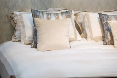 Modern bej ve kahverengi kumaş yastıklar temiz yatağın iç kısmında ve canlı akitektür dekorasyonu çağdaş konforlu rahatlama konsepti için.