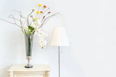Antika beyaz ahşap dolap ve ayakta duran lamba ampulü vazo camlı güzel çiçek ev için beyaz duvar iç dekorasyonu ve canlı akitekt dekorasyonu çağdaş konsept