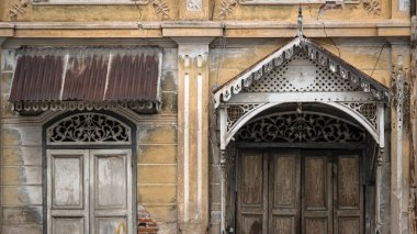 Güzel antik ahşap oyma pencereler ve sıva desenli eski sarı tarihi bina dış mimarisi Tayland 'da