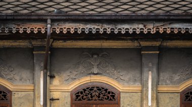 Güzel antik ahşap oyma pencereler ve sıva desenli eski sarı tarihi bina dış mimarisi Tayland 'da