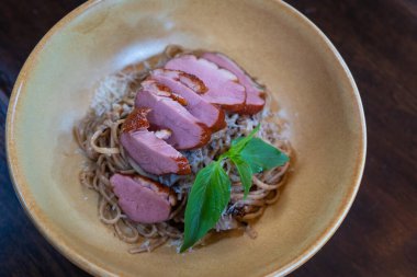 Peynirli makarna ve füme ördek göğsü Tayland İtalyan füzyon yemekleri ahşap masada lezzetli yemekler.