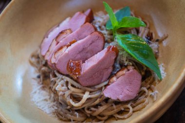 Peynirli makarna ve füme ördek göğsü Tayland İtalyan füzyon yemekleri ahşap masada lezzetli yemekler.