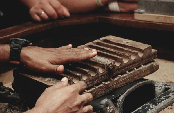 Produção tradicional de charutos. Mãos close-up charutos torção de folhas de tabaco — Fotografia de Stock