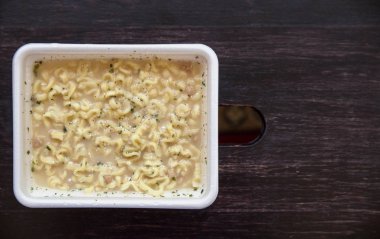 Çin anlık erişte, plastik dikdörtgen Fincan demlenmiş. Ahşap kahverengi bir arka plan üzerinde erişte yakın çekim. Metin için yer.