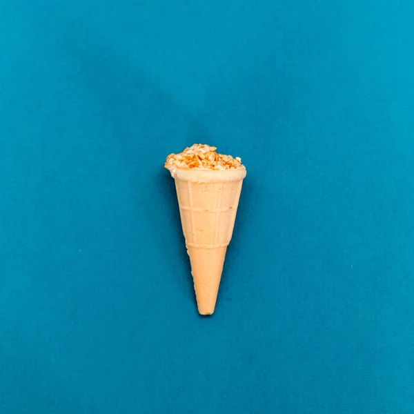 Ice cream with nuts in a waffle Cup, on a blue background — Stock Photo, Image