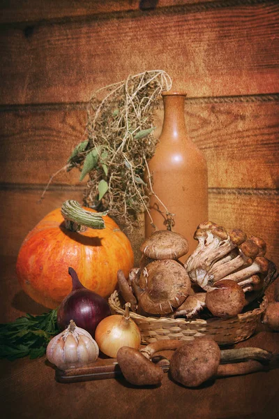 Сельский натюрморт овощей и керамических бутылок. На деревянном столе тыквенные грибы Armillaria, лук петрушки чеснок и нож. Деревянный фон . — стоковое фото