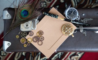 Bir yakın çekim mesajı için boş bir vintage kartpostal, bir vites kilidi ile, bir zincir ve kadın takı karanlık bir arka plan üzerinde yatan bir saat. Steampunk ve Viktorya dönemi tasarımı için kullanılabilir.