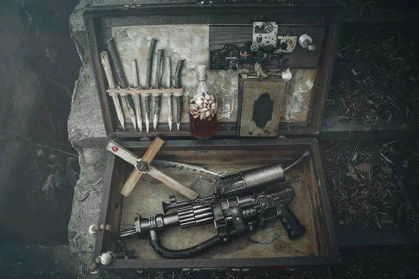 A set of things hunter evil spirits, demons, vampires in an old suitcase. An old book with spells, aspen stakes, tincture of garlic and Holy water, rosary, cross and gun. The view from the top. — Stock Image A set of things hunter evil spirits, demons, vampires in an old suitcase. An old book with spells, aspen stakes, tincture of garlic and Holy water, rosary, cross and gun. The view from the top. Royalty Free Stock Photos