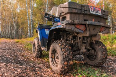 Dörtlü bisiklet yolda. Sonbahar ormanlarında mavi bir ATV POLARIS Quad bisikleti yolda duruyor. SUV 'un arkası toz toprak ve yakın plan görüntülerle kaplı. Rusya, Krasnoyarsk bölgesi, 23 Eylül 2016
