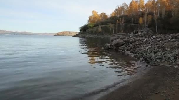 Waves hit the rocky and rocky shore against — Stock Video