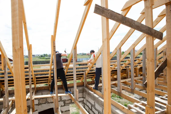 Rögzítők és tetőgerendák beszerelése a munkások által. Felkészülés a palatáblára. Ácsmunka kivitelezése és beszerelése. Abakan, Oroszország - 2020 június 8. — Stock Fotó