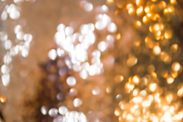 Yellow-gold garlands with a blurred focus in the form of a bokeh. Abstract colorful background with gold bokeh in the form of sequins and fish scales. — Stock Photo, Image