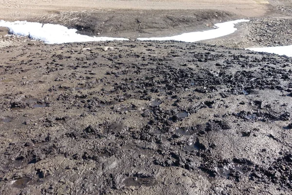 水溜りや泥でオフロードSuvのための川底に沿ってフィールドや山を介して過酷な自然景観や道路 ぬれた大地と雪に包まれた春の背景 — ストック写真