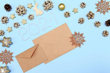 Noel oyuncaklarıyla dolu bir Noel mektubu. Yay, kar taneleri, kozalak ve yıldızlı altın madalyalı Noel arkaplanı. 2021 'de Noel Baba' ya bir mektup