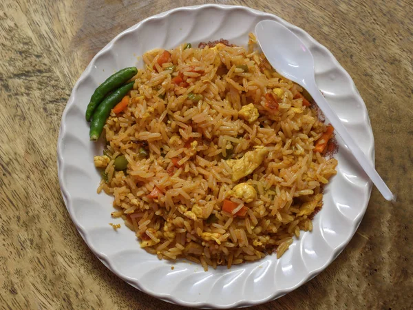 Fried rice is a dish of cooked rice that has been stir-fried in a wok or a frying pan and is usually mixed with other ingredients such as eggs, vegetables, seafood, or meat.