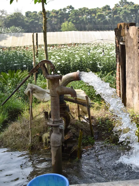water supply shallow machine water pump supply farm land green flow grass.