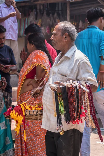 Tarakeswar, India – 21 2019 april; Een man verkoopt bloemen, Rudraksha Mala, rode draad of Heilige draden, God medaillon, slingers in Baba Taraknath Temple, een hindoe tempel gewijd aan God Shiva. — Stockfoto