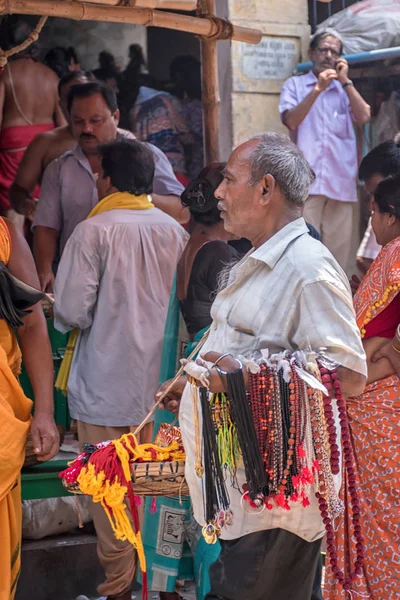 Tarakeswar, Índia - 21 de abril de 2019; Um homem vendendo flores, rudraksha mala, fios vermelhos ou fios sagrados, medalhão de deus, guirlandas no Templo Baba Taraknath, um templo hindu dedicado ao deus Shiva . — Fotografia de Stock