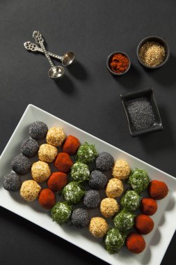 baharatlı, susam, mavi haşhaş, kırmızı biber, maydanoz peynir topları meze ile peynir tabağı üst görünümü 