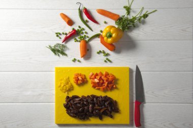 dilimlenmiş sebze ve bıçak ile kesme tahtası üst görünümü