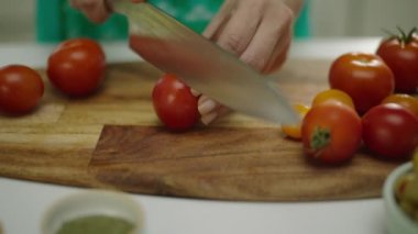 Ahşap tahta üzerinde kadın eller kesme domates yavaş hareket