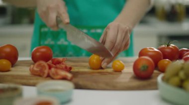 Ahşap tahta üzerinde kadın eller kesme domates yavaş hareket