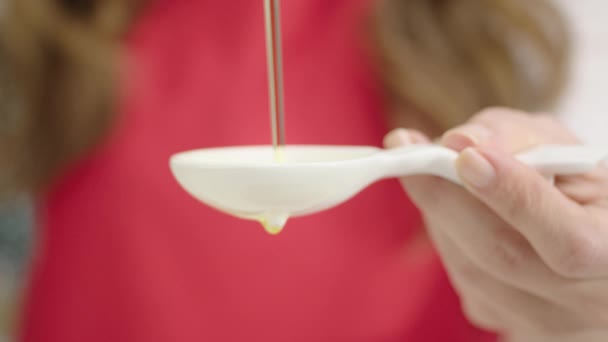 Cámara Lenta Mujer Vertiendo Aceite Cuchara Blanca — Vídeos de Stock