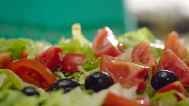 沿着卷曲沙拉与橄榄和西红柿运动 — 图库视频影像