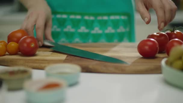 木製のボード上のトマトを切断する女性の手のスローモーション — ストック動画