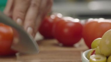 Ahşap tahta üzerinde kadın elleri kesme domates yakın yukarı, yavaş hareket