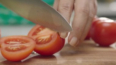 Ahşap tahta üzerinde kadın elleri kesme domates yakın yukarı, yavaş hareket