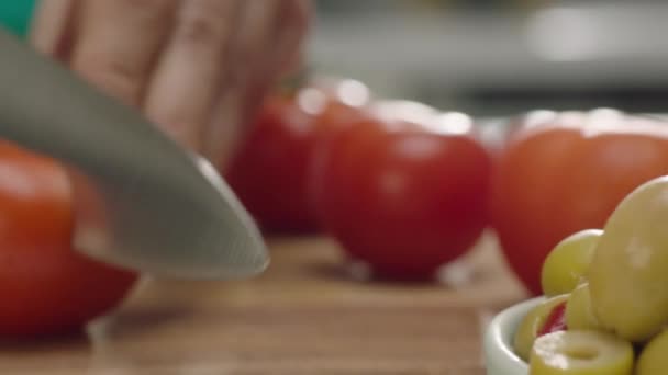 木製のボードにトマトを切る女性の手のクローズアップ — ストック動画