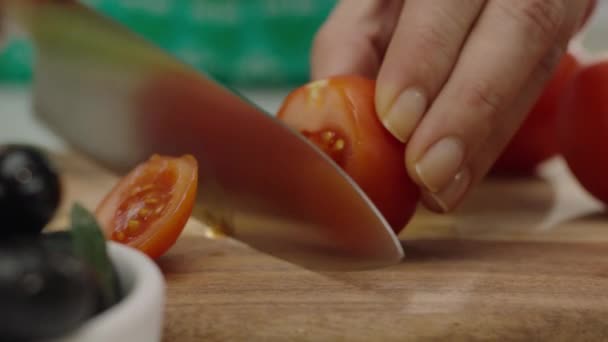 木製のボード上のトマトを切断する女性の手のクローズアップ スローモーション — ストック動画