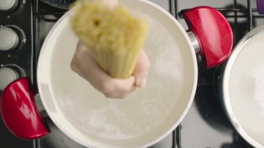 kaynar su ile Pan içinde makarnalar koyarak kadın el yavaş hareket