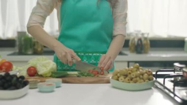 Ahşap tahta üzerinde kadın kesme domates yakın yukarı 