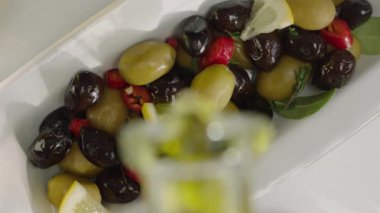 Beyaz plaka yağ ile dökme limon dilimleri ile yeşil ve siyah zeytin üst görünümü