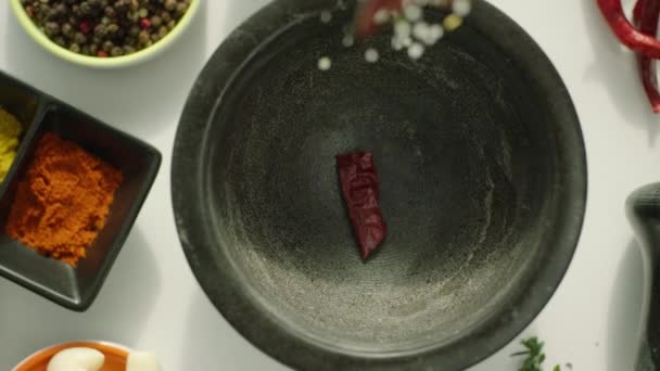 Zeitlupe Von Pfeffer Und Knoblauch Fällt Mörser Auf Küchentisch — Stockvideo
