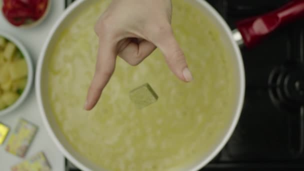 女性手在汤中投掷辣立方体的慢动作 — 图库视频影像