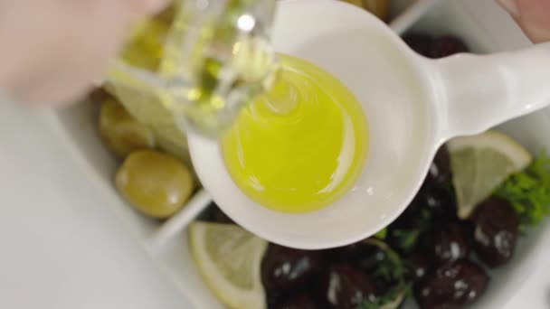 白皿に油を注ぐ女性の手のスローモーション — ストック動画
