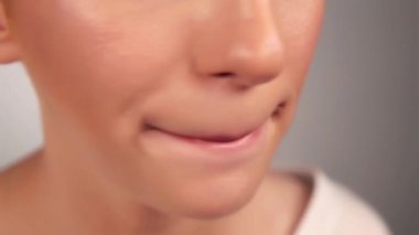 Genç bir kadın pembe ruj sürüyor, yakın plan.