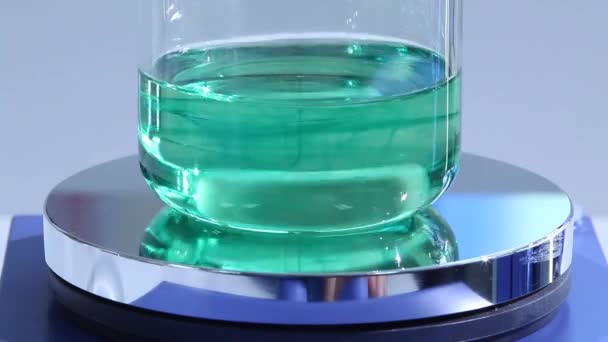 在实验室里 用磁性鱼配制蓝色的化学混合物 使液体从透明变为蓝色 — 图库视频影像