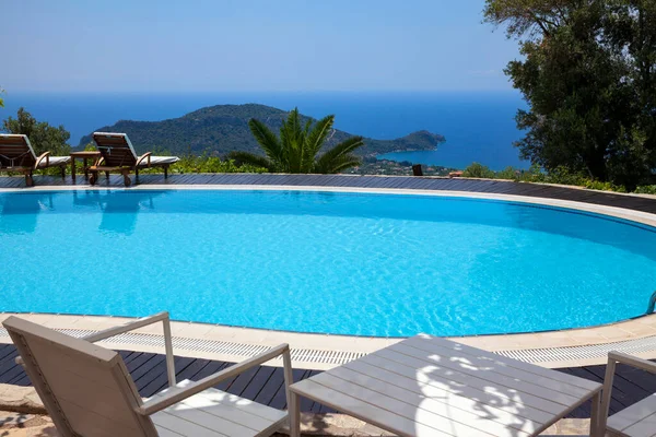 Swimming pool in the garden and beautiful mountain landscape with trees.