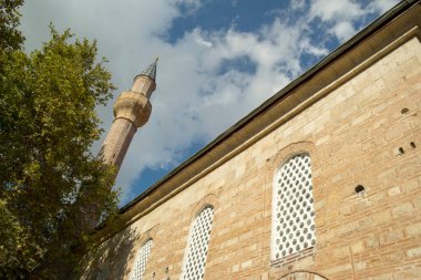Geleneksel Osmanlı mimarisi camisi, mavi gökyüzü, bulutlar ve ağaç