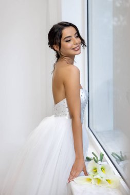 Parlak beyaz balo elbisesi içinde, çiçekli, zarif ve romantik gelin portresi olan mutlu gelin.