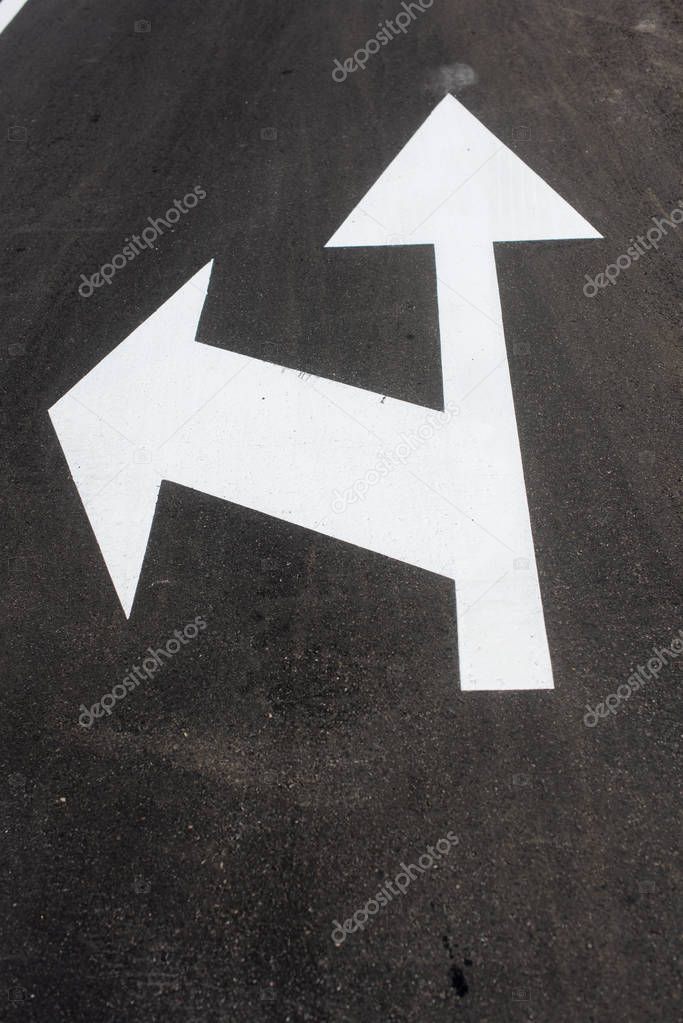 Two white arrows on asphalt. Street sign down for transportation