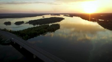Ağaçlar, Adaları, arabalar, yol ve ayar güneş üzerinde görünümü. 
