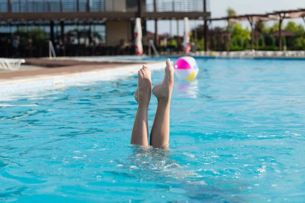 Mooie vrouwelijke benen stok uit water — Stockfoto