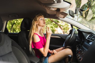 Kız dudak parlatıcısı araba ayna ile koymak